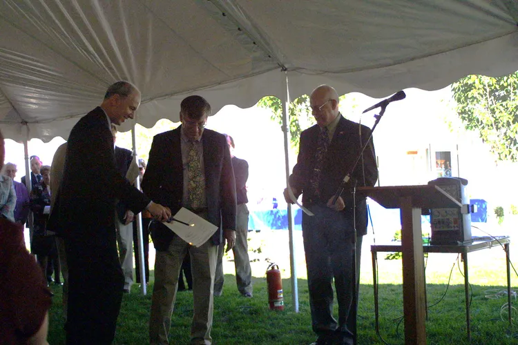 Pastor Doug burns the mortgage while Bill and others look on